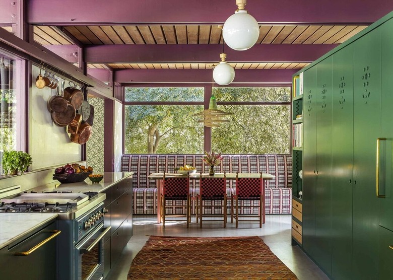kitchen with exposed plum-colored beams and floor-to-ceiling green cabinets