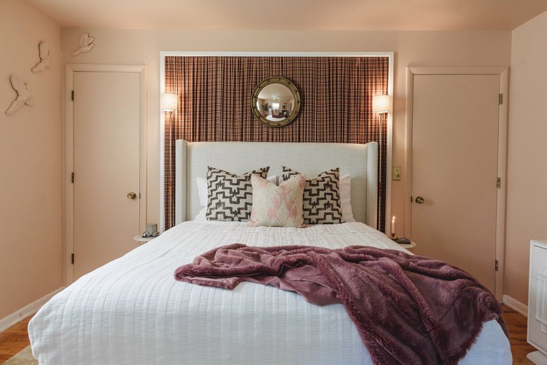 A bedroom with a brown plaid headboard