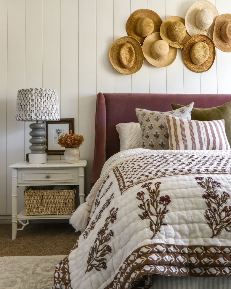 A bedroom with a plum headboard