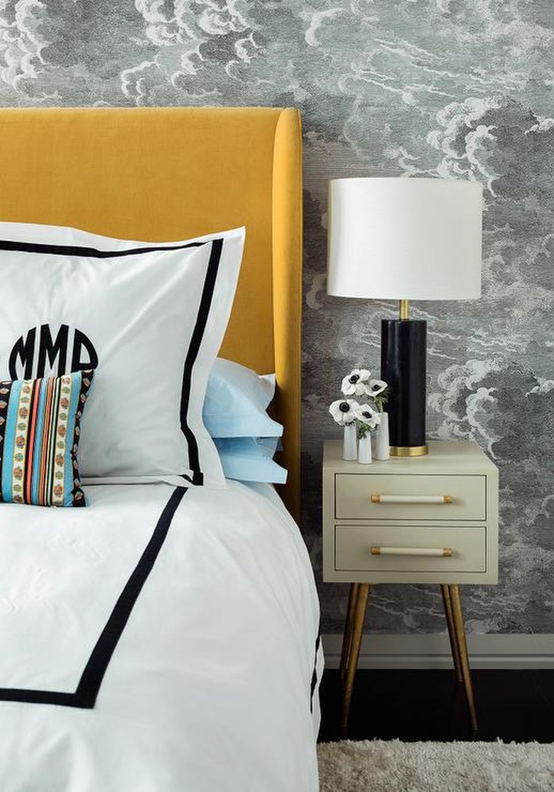 black and white bedroom with yellow headboard