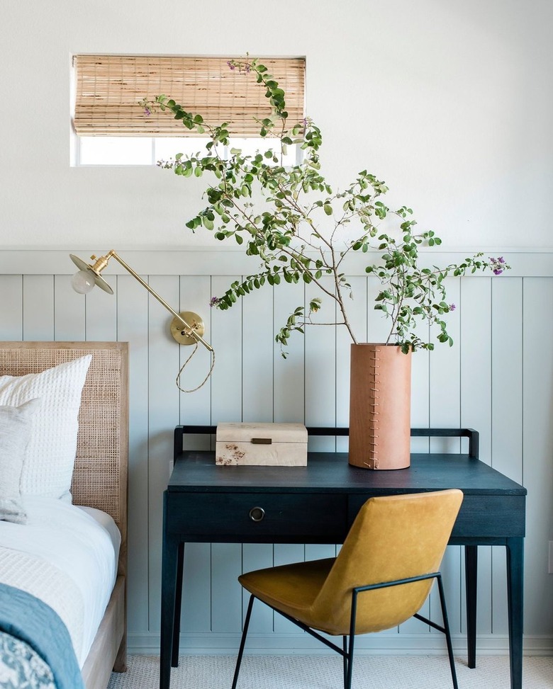 blue and white bedroom with mustard chair