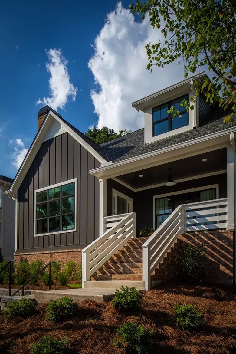 House with brown brick lower section and dark brown siding