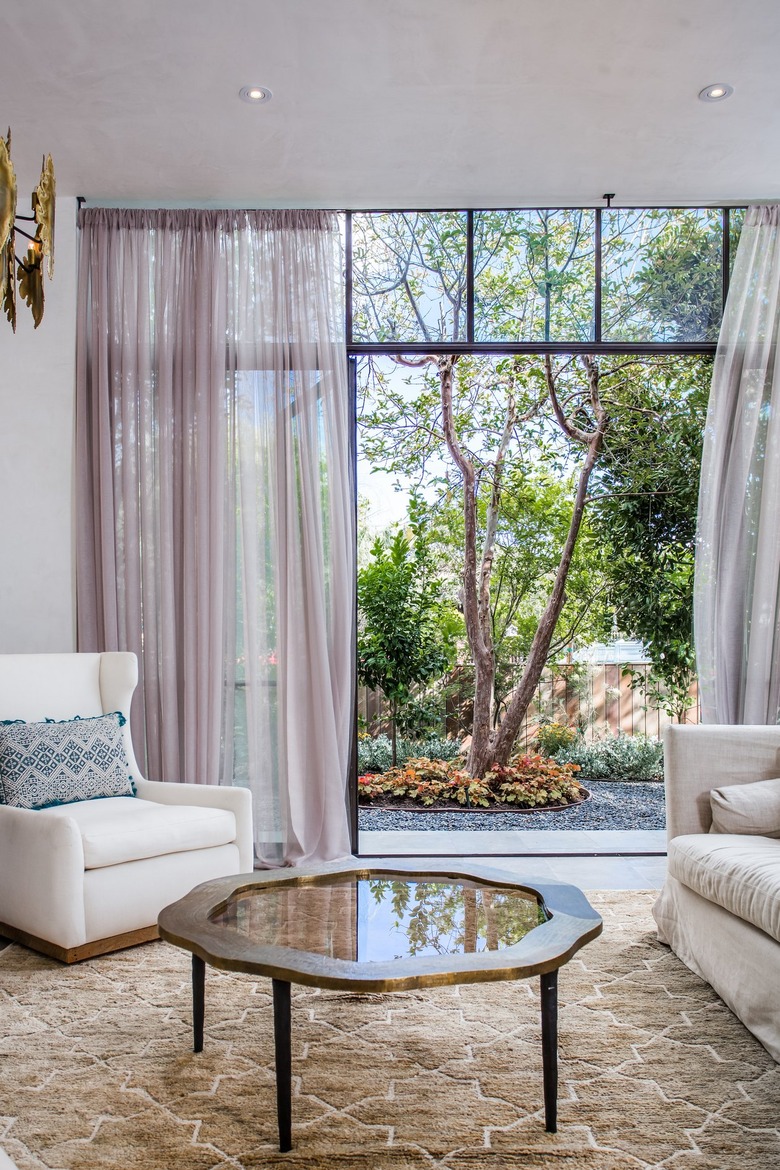 Living room with brown area rug and lavender walls