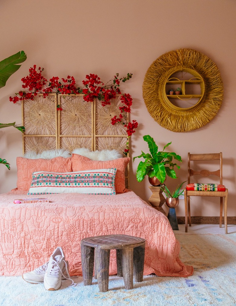 peach boho bedroom with rattan headbaord and mirror