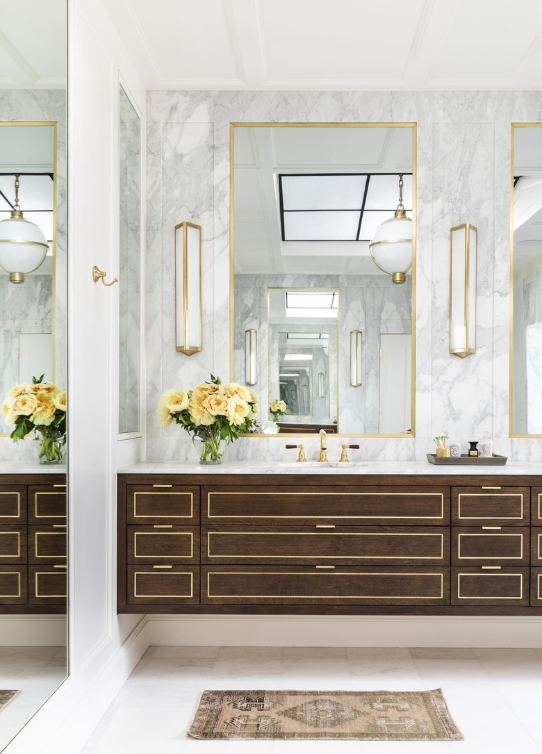 Bathroom by Marie Flanigan Interiors with gold accents and natural wood cabinetry