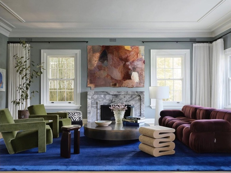 Living room with maroon couch and blue carpets.