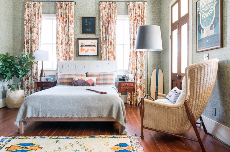 Olive green walls with orange curtains in this bedroom by Cortney Bishop Design