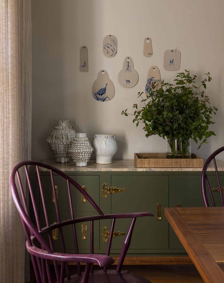 dining room with purple chairs and sage green cabinet