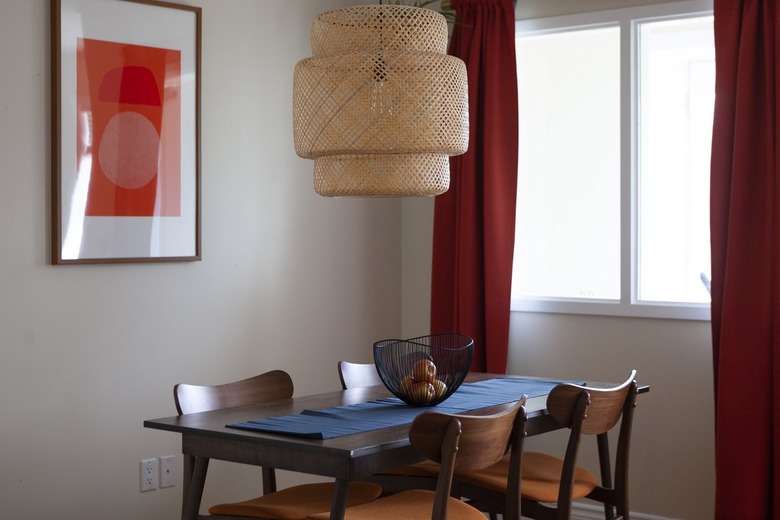 Boho pendant light hanging over wood dining table