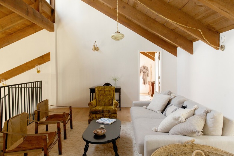 A living room with a slanted wood beam ceiling