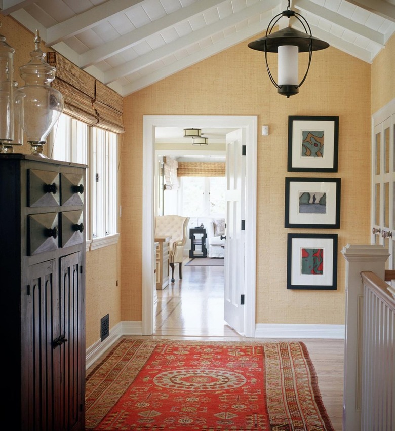 landing with tan wallpaper and red area rug