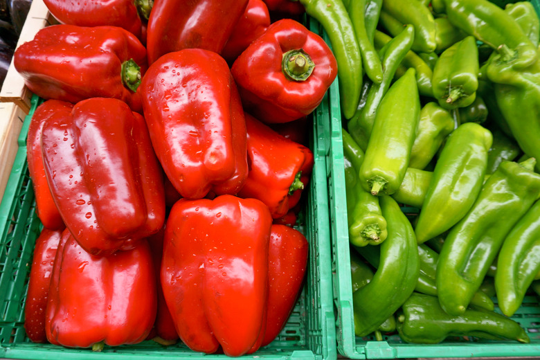 Fresh red bell pepper and green chili in green plastic box