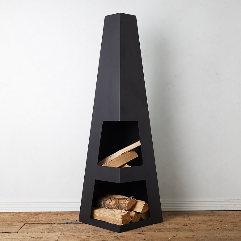 Obelisk-shaped contemporary fire pit with logs on white background