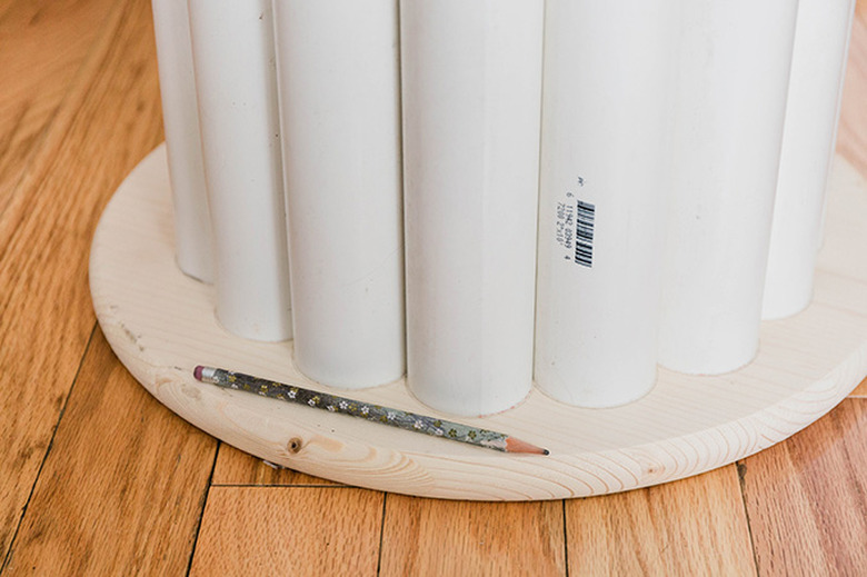 Use a pencil to lightly trace the scalloped shape of the concentric pipes onto the underside of the wood tabletop.