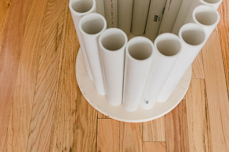 Lay the cut pipes out in a circle around the underside of the wood tabletop.