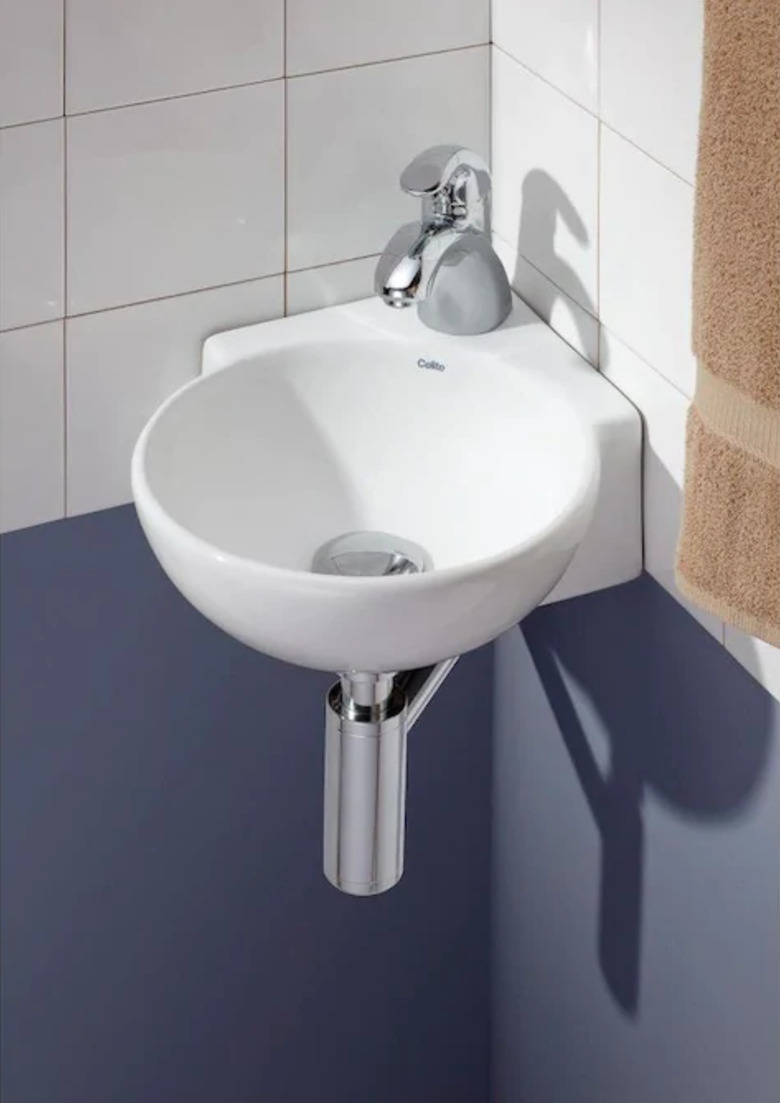 Semi-circle wall mount corner bathroom sink against white tile backsplash