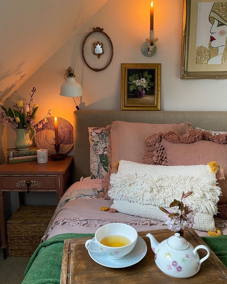 bedroom lit by candles with tea tray on bed