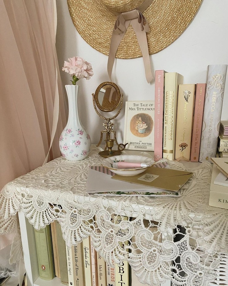 bookshelf with lace cover and pastel-colored books