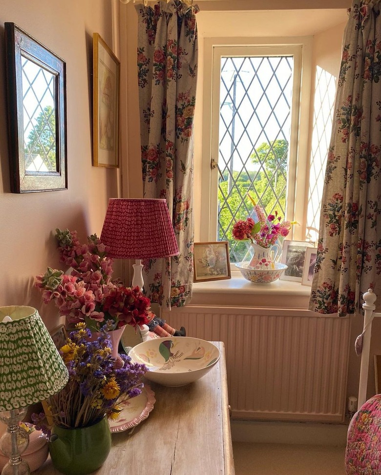 window with floral curtains and vase of fresh flowers