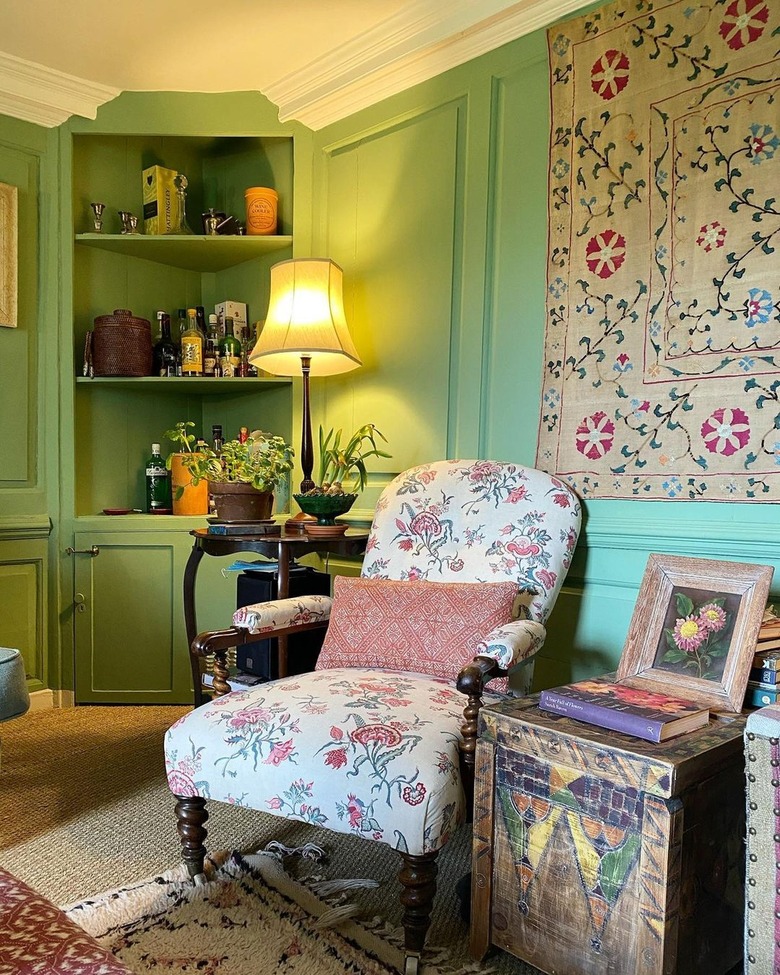 living room with green walls and vintage furniture and textiles