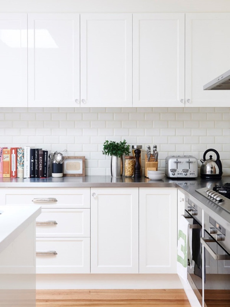 Gray stainless steel countertops on white kitchen cabinets