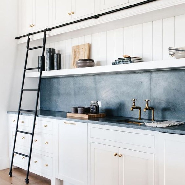 kitchen with white cabinets and slate blue countertop and backsplash