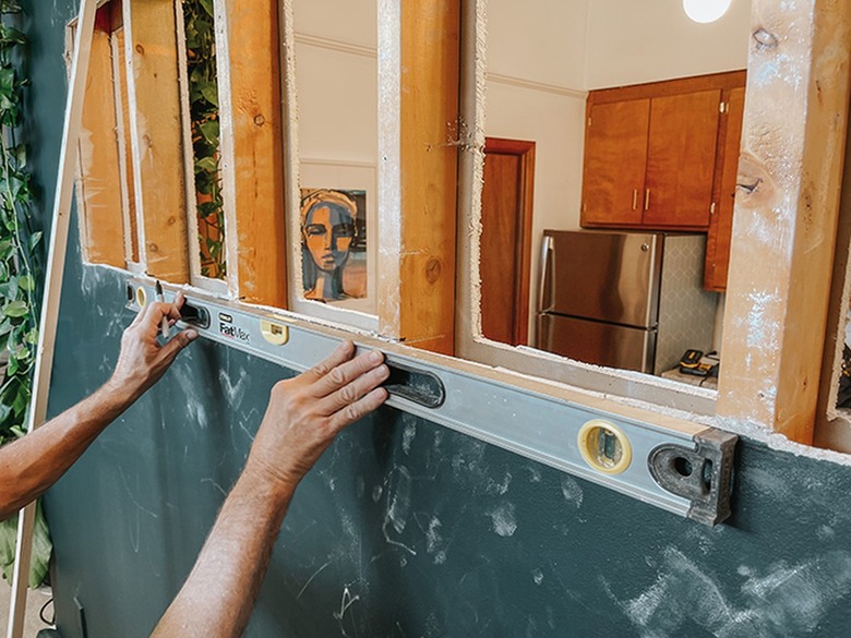 Mark the studs at the cut point using a level.