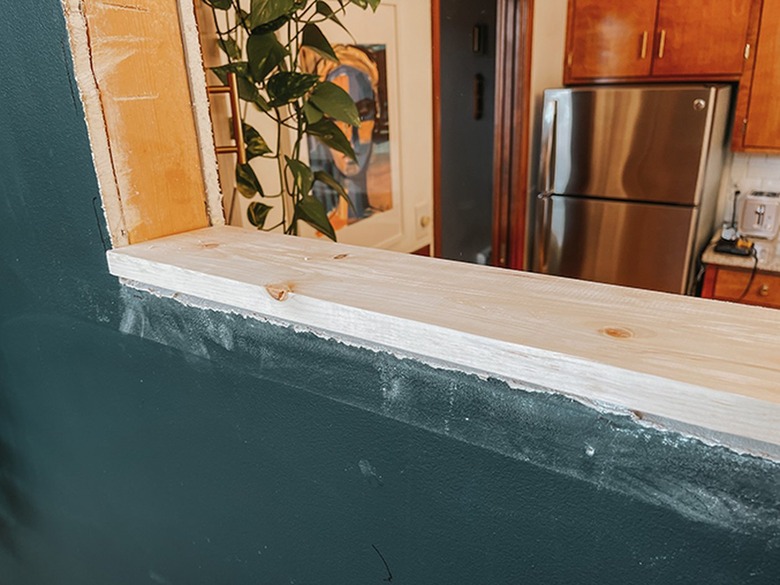 Screw in the interior trim along the cutout.