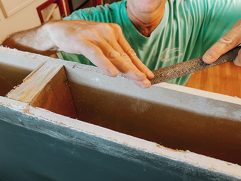 Clean any rough patches on the cut drywall using a rasp.