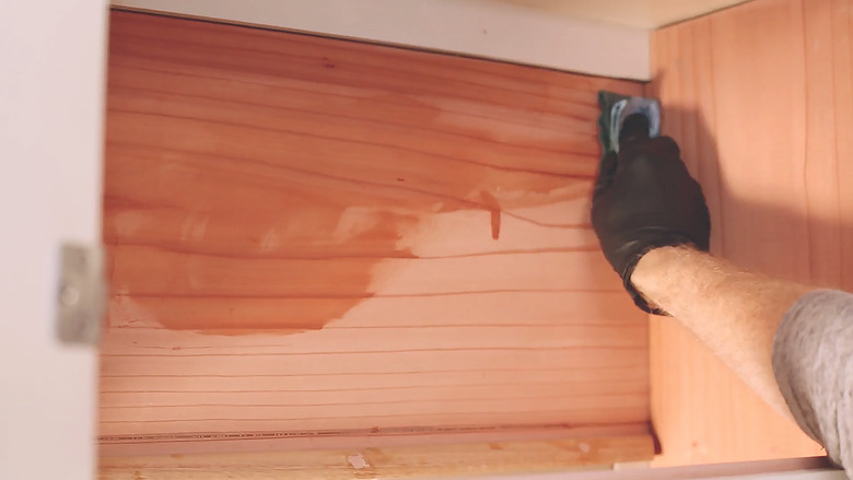 Wiping boiled linseed oil on cabinet