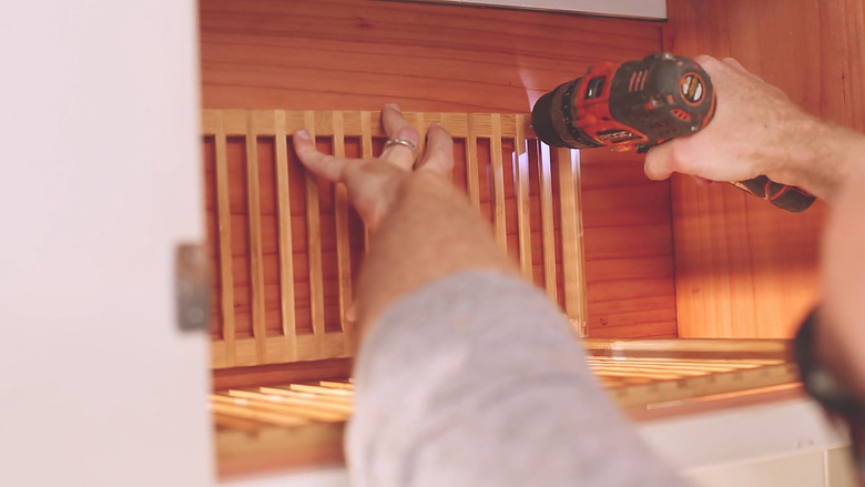 Attaching plate rack support inside cabinet