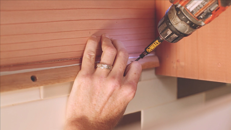 Attaching cedar support beam inside cabinet