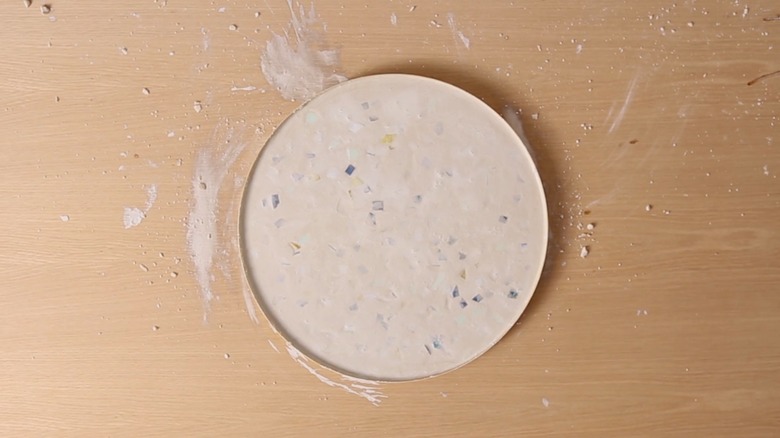 Wet cement and glass chips for terrazzo tabletop