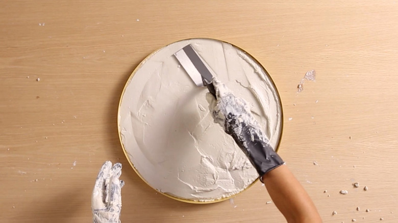 Smoothing wet concrete with finishing trowel