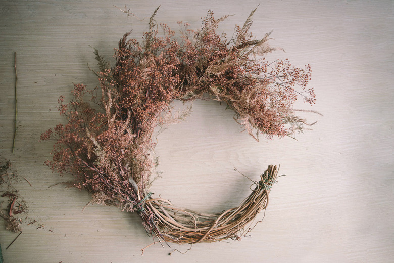 Top half of crescent wreath filled with dried floral bundles