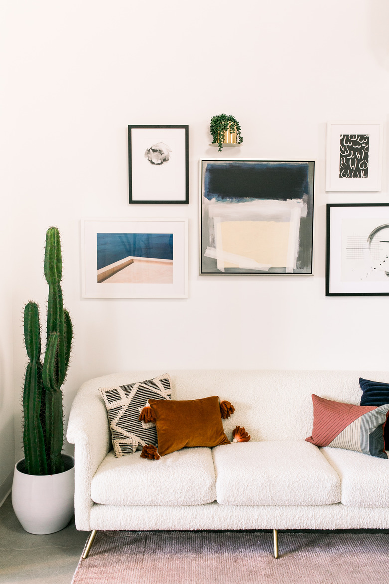 Couch and gallery wall in Jaclyn Johnson's office at Create & Cultivate headquarters
