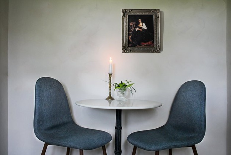 Limewash walls with blue dining chairs and table.