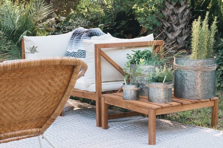 Outdoor herb garden in tin planters on patio.