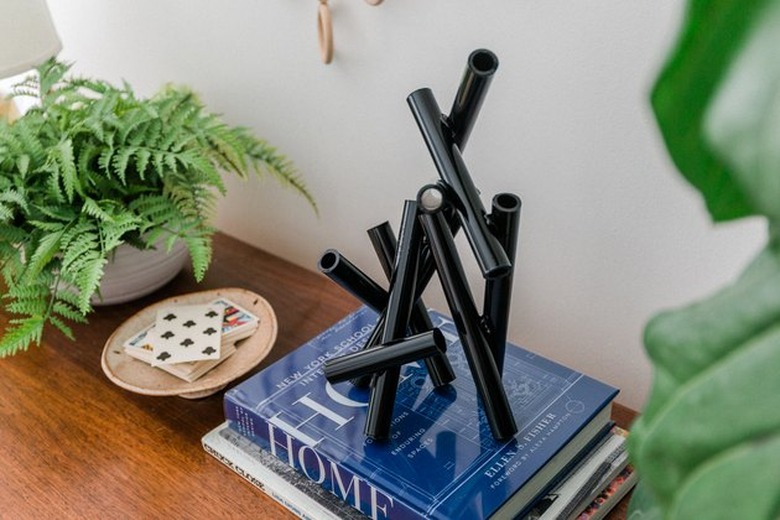 PVC sculpture on desk with plants and books.