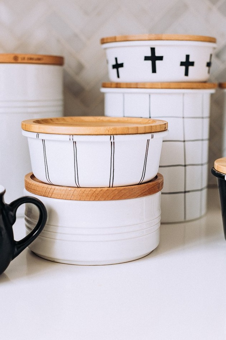 Black and white painted glass jars with wood tops.