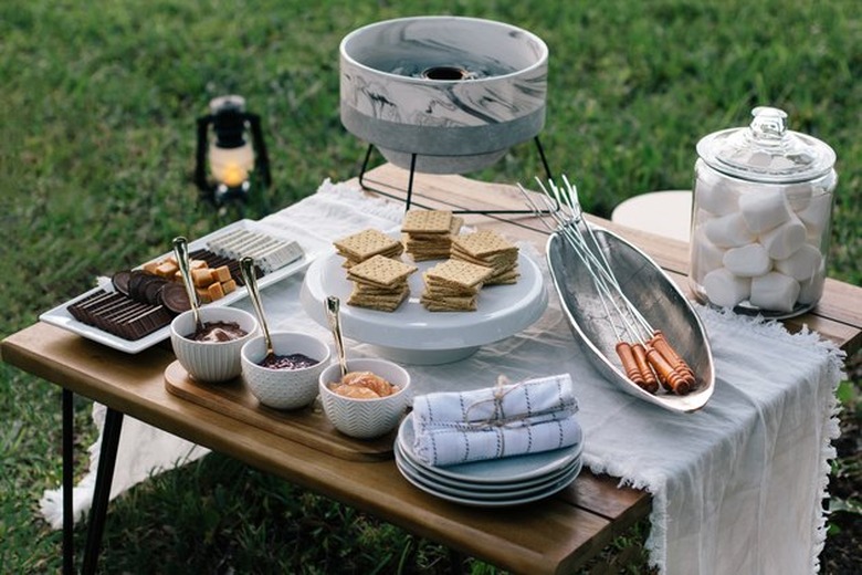 S'mores station set up in backyard on table.