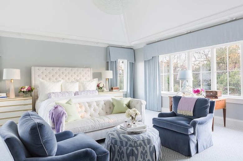 Bedroom with blue-gray walls and light blue curtains.