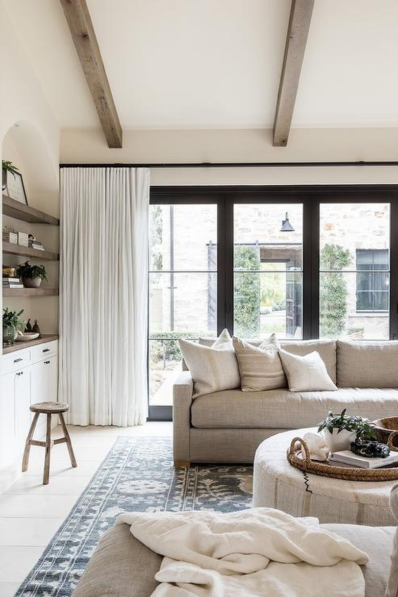 Light linen curtains in a large family room against beige walls