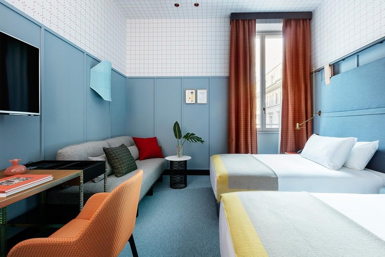 hotel room with blue walls and orange curtains