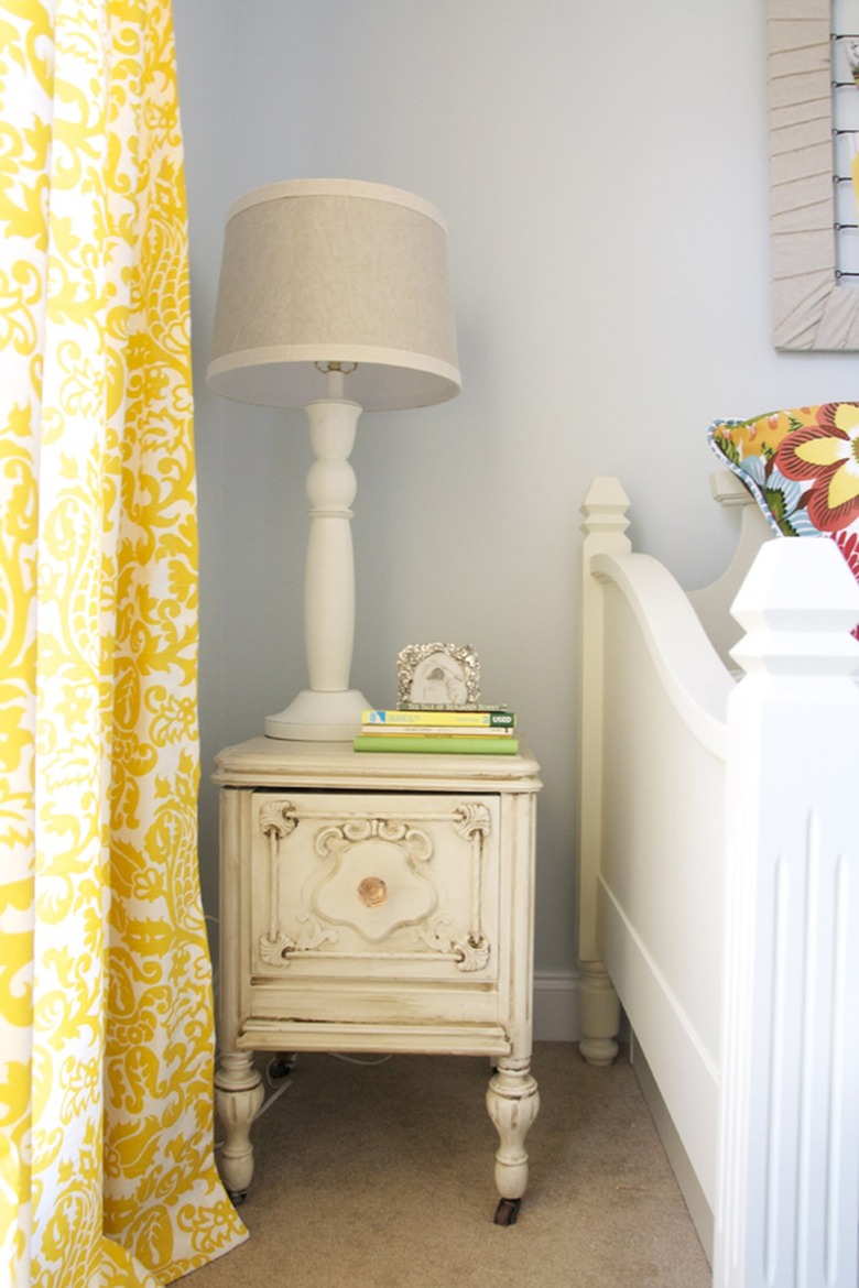 A sky blue kids room with yellow paisley curtains.