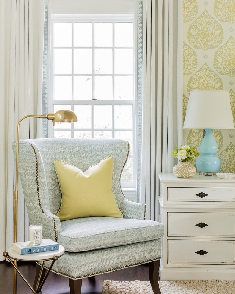 Room corner with pastel blue and white patterned side chair with yellow accent pillow