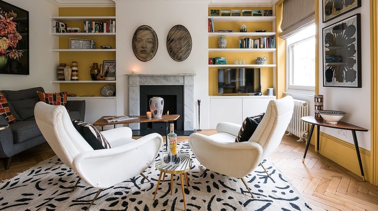 A living room with yellow and white walls and taupe window treatments