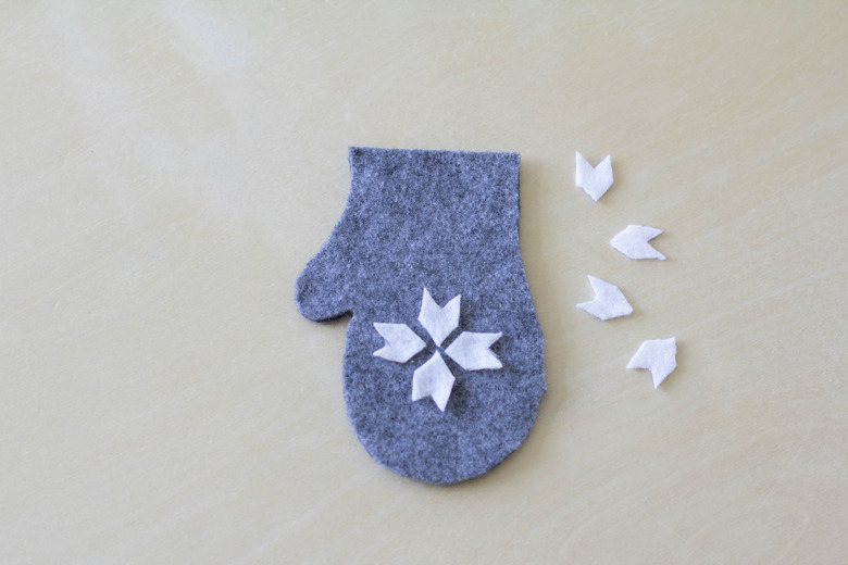 Gluing felt snowflake on top of mitten