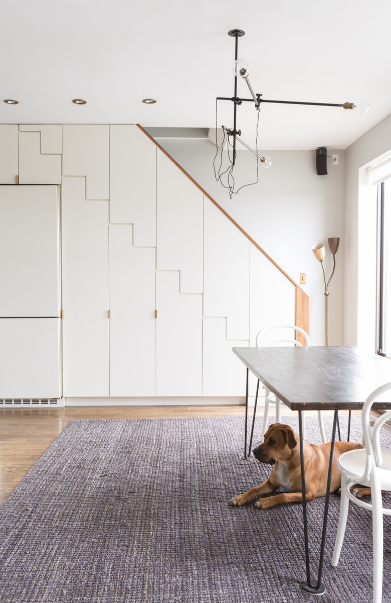 Dog rests under dining room table