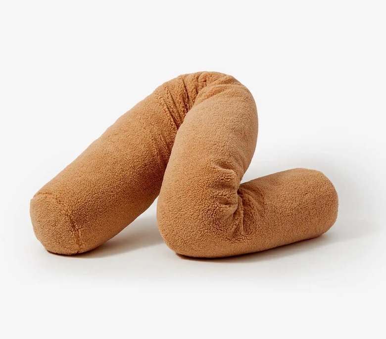 A brown sherpa long pillow that can be maneuver to look like a squiggle.